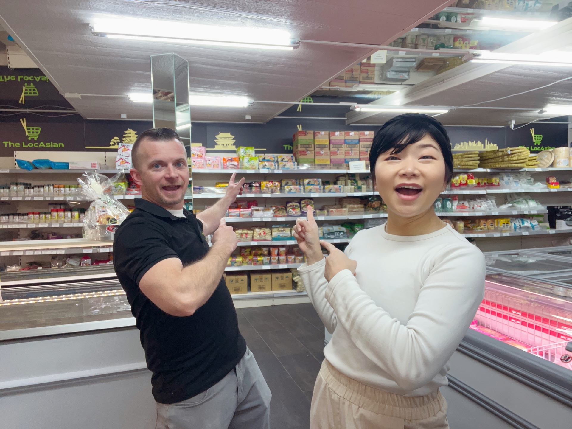 Two people pointing at products at thelocasian.com